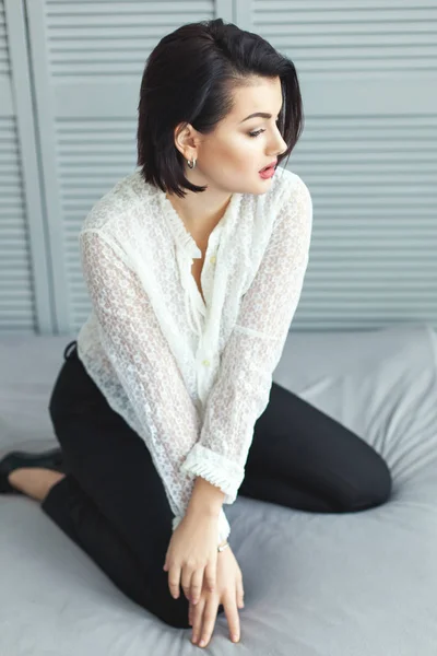 Woman in diaphanous shirt on the bed. — Stock Photo, Image