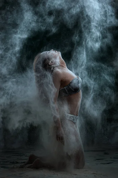 Jente i en sky av støv fra mel . – stockfoto