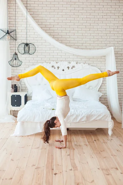 Kvinna gymnasten gör akrobatiska handstående. — Stockfoto
