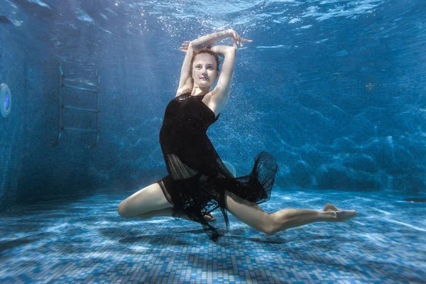 Woman dances under the water in the pool. — Stock Photo, Image
