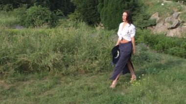 Kadın parkta çimlerde yürüyor.