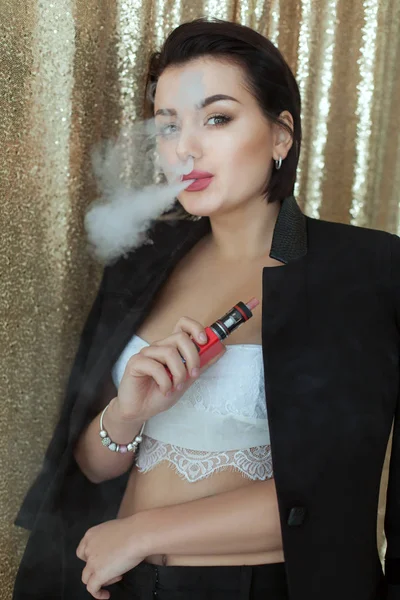 Woman smokes an electronic hookah. — Stock Photo, Image