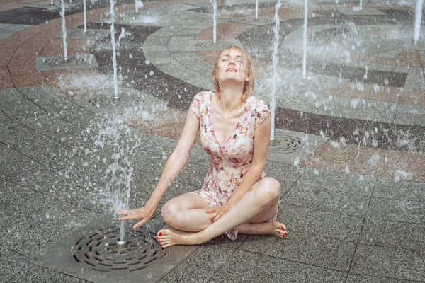 女性は噴水に座っています。. — ストック写真