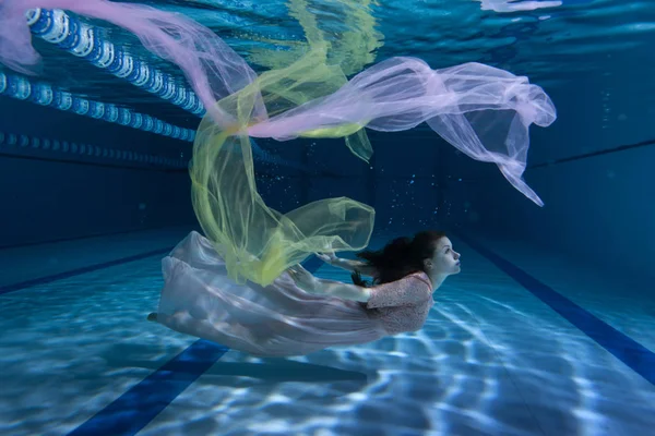 Swimmer underwater playing with cloth. — Stock Photo, Image