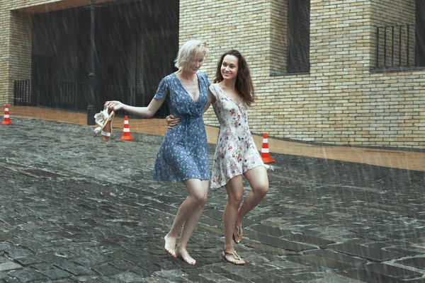 Mujeres bajo la lluvia en la ciudad . — Foto de Stock