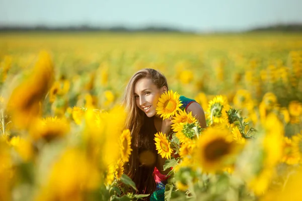 Vrouw onder gele zonnebloemen. — Stockfoto