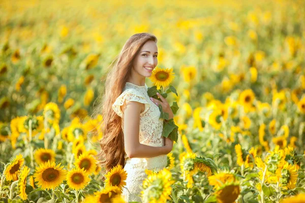 Lächelnde Frau in Sonnenblumen. — Stockfoto