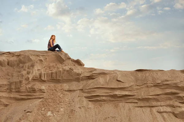 Kadın oturur yüksek bir dağ.