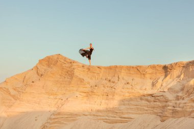 Kadın kum tepeleri yokuş aşağı çalışır.
