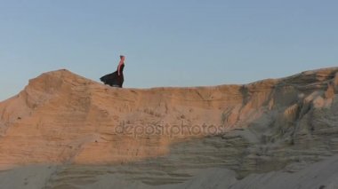 Kadın çölde dans ediyor.