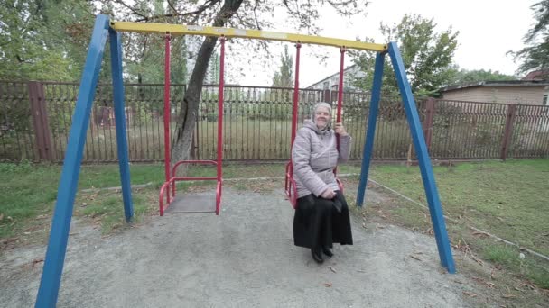 Old grandmother on a swing. — Stock Video