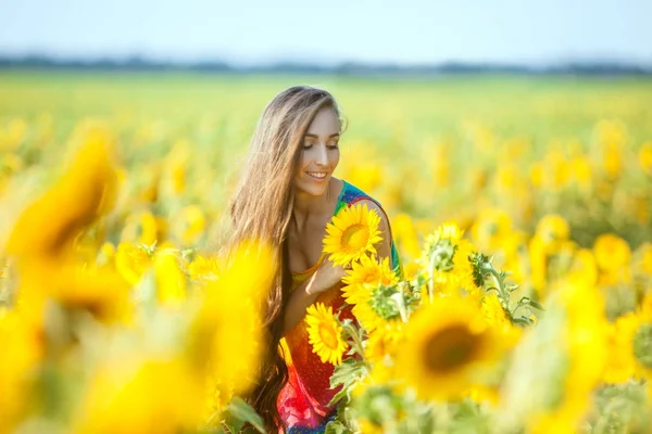 Frau auf dem Feld mit Blumen. — Stockfoto