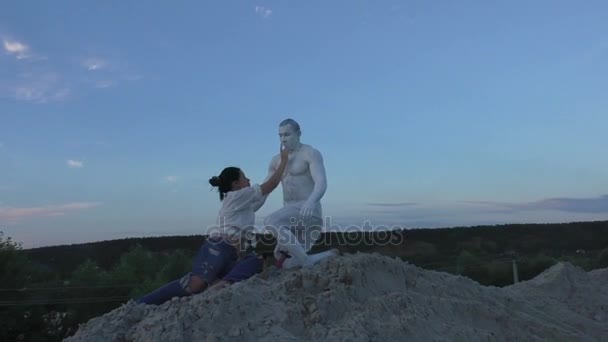 Mujer toca a un hombre con una estatua . — Vídeo de stock