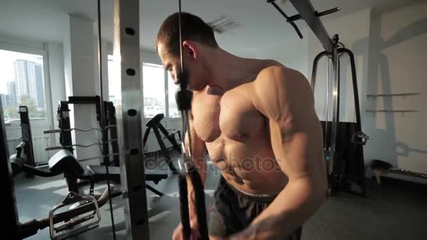 Guy está entrenando en el gimnasio . — Vídeos de Stock