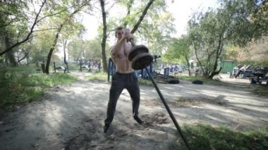 Atlet crouches dumbbells ile.