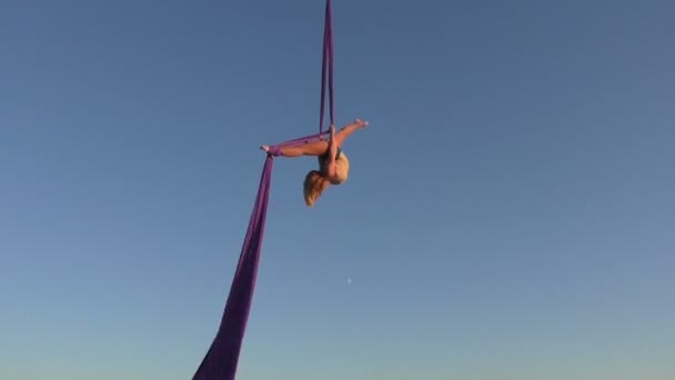 Acrobat-kvinna som hänger på siden i himlen. — Stockvideo