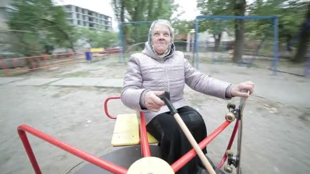 Den gamla kvinnan roterar snabbt på en gunga. — Stockvideo