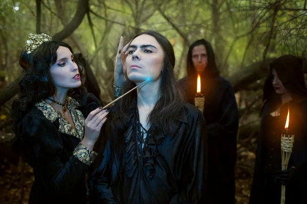 Young woman witch conjures over a young man. — Stock fotografie