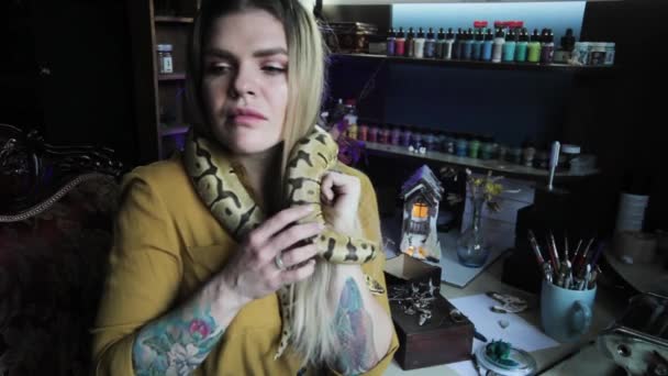 一个女人被蛇缠住了 她在自己的工作室里和蛇玩耍 — 图库视频影像