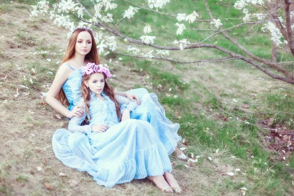 庭に咲くマグノリアの近くに美しい母親と娘の肖像画 — ストック写真