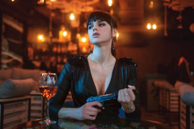 Elinde silahla güzel ve seksi bir kadının portresi..