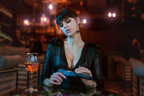 Sexy Young Woman Sits Table Holds Gun Her Hands — Stock Photo, Image