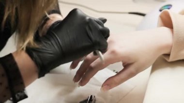 Manikürcü güzellik salonunda manikür yapıyor. Tıp, kozmetoloji ve manikür. Yakın plan..