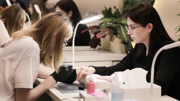 指甲沙龙温泉治疗 漂亮的年轻女人在美容院里让美容师给她做指甲 — 图库视频影像
