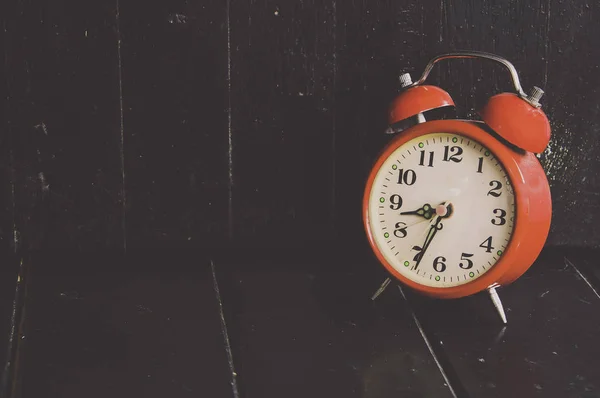 Red clock on wood background