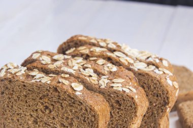 Beyaz ahşap zemin üzerinde taze bütün tahıl ekmeği