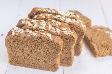 Beyaz ahşap zemin üzerinde taze bütün tahıl ekmeği