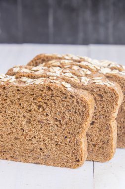 Beyaz ahşap zemin üzerinde taze bütün tahıl ekmeği