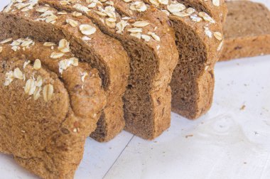 Beyaz ahşap zemin üzerinde taze bütün tahıl ekmeği