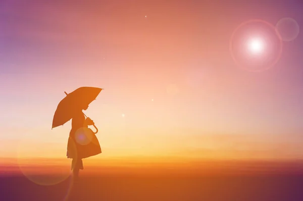 Umbrella little girl stand and sunset silhouette. — Stock Photo, Image