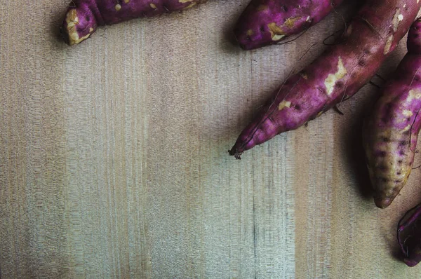 Purple Sweet Potatoes on a wooden table,Healthy food.