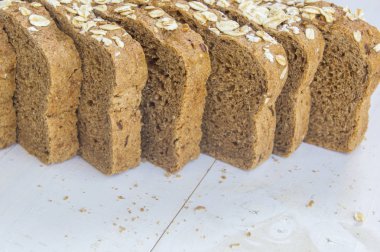 Beyaz ahşap zemin üzerinde taze bütün tahıl ekmeği