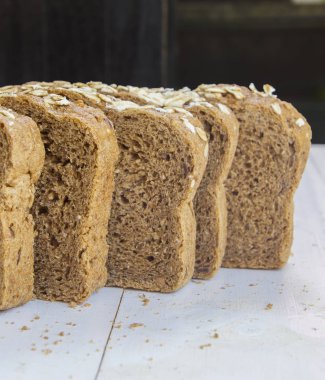 Beyaz ahşap zemin üzerinde taze bütün tahıl ekmeği