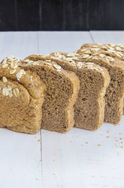 Beyaz ahşap zemin üzerinde taze bütün tahıl ekmeği