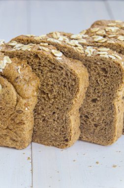 Beyaz ahşap zemin üzerinde taze bütün tahıl ekmeği