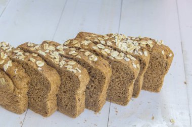 Beyaz ahşap zemin üzerinde taze bütün tahıl ekmeği