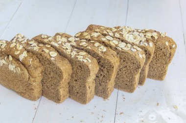 Beyaz ahşap zemin üzerinde taze bütün tahıl ekmeği