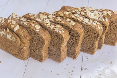 Beyaz ahşap zemin üzerinde taze bütün tahıl ekmeği