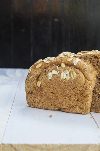 Färskt fullkornsbröd på vit trä bakgrund — Stockfoto