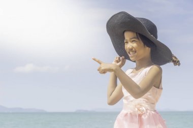 Kumsalda oynayan mutlu küçük kız.