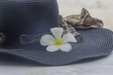 Beyaz ahşap zemin üzerinde şapka Summer'la closeup çiçek.