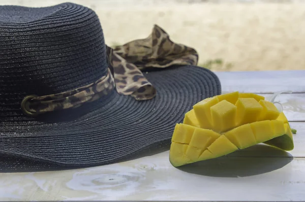 Fruta de mango con sombrero sobre fondo marino de madera blanca . — Foto de Stock