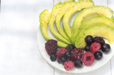 Sağlıklı kahvaltı malzemeler avokado dilimleri ile karıştırın çilek bir