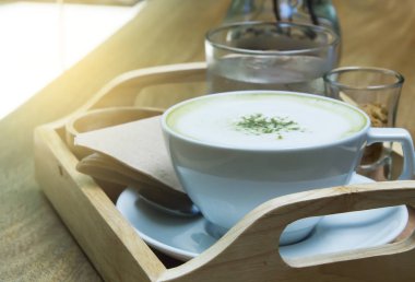 Ahşap arka plan üzerinde tozu matcha yeşil çay sütlü.