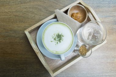 Ahşap arka plan üzerinde tozu matcha yeşil çay sütlü.