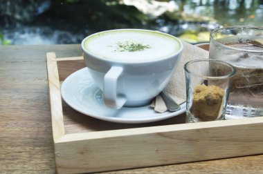 Ahşap arka plan üzerinde tozu matcha yeşil çay sütlü.